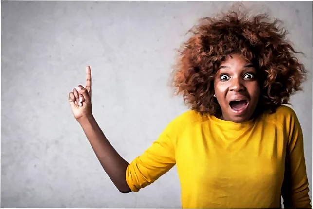 Mujer con jersey amarillo señalando arriba. TdEs hace curso de pastelería presencial en Barcelona